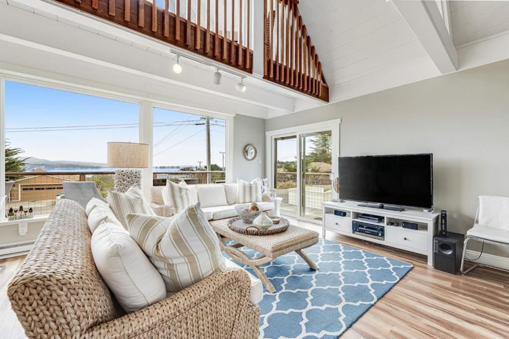 a living room with white furniture and a flat screen tv at Whaleship Harbor View in Bodega Bay