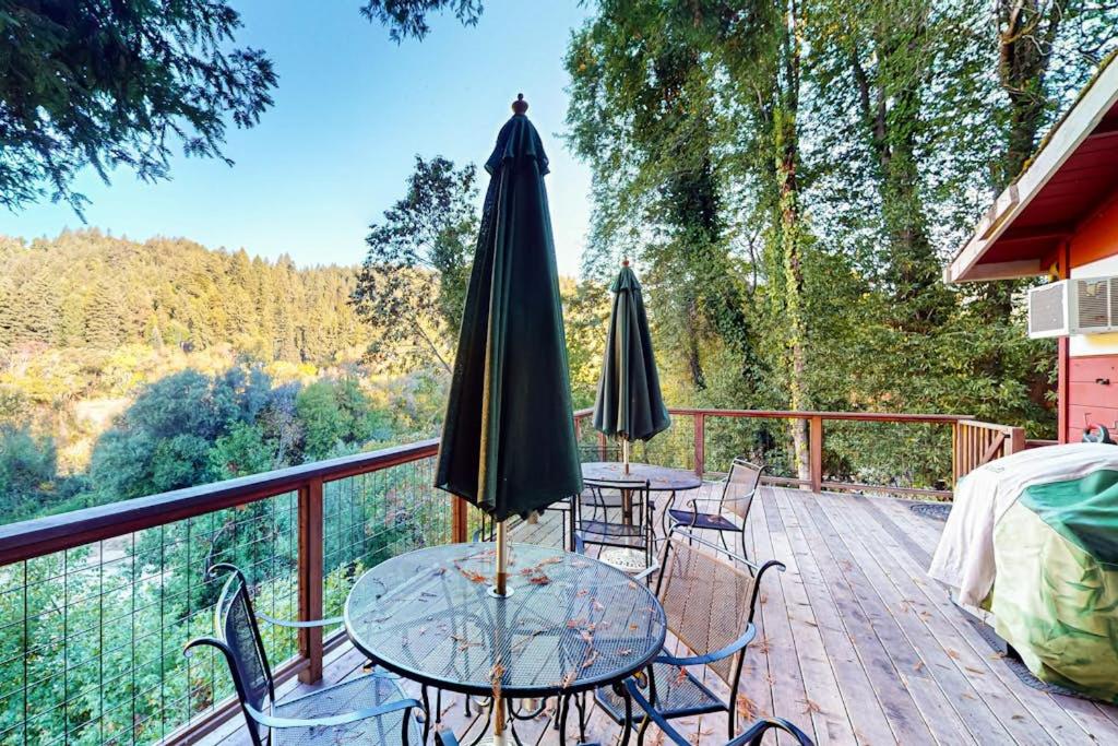 two tables and chairs with an umbrella on a deck at Villa Eileen in Guerneville