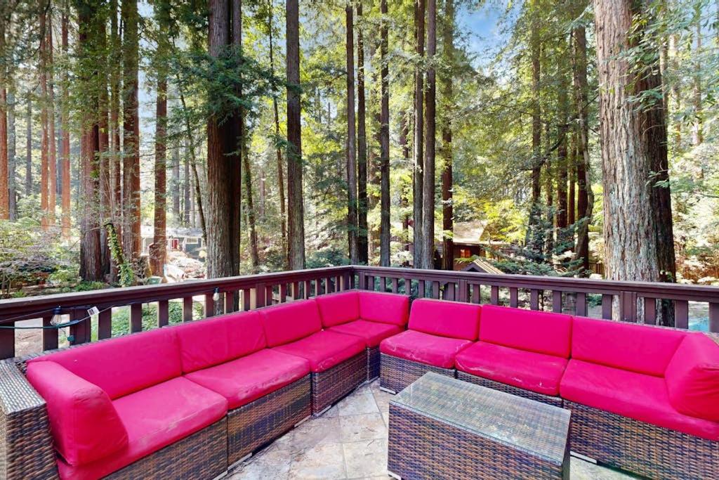 a pink couch sitting on a deck in the woods at Monte Rio Dream in Monte Rio