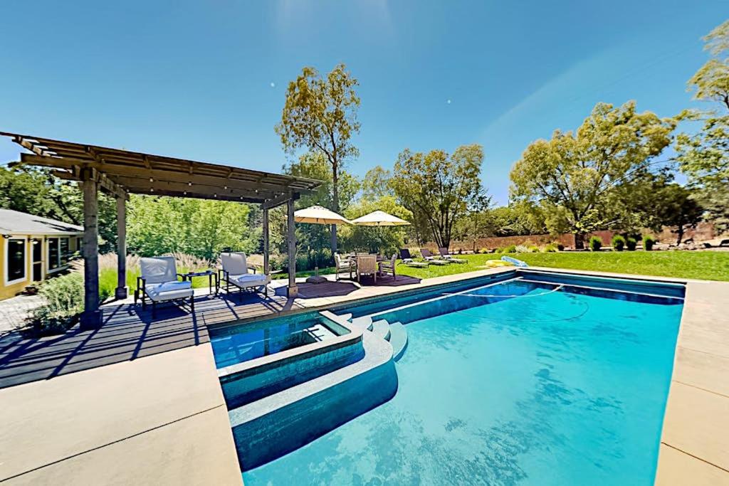 a swimming pool with two chairs and a pavilion at Warm Springs Paradise in Glen Ellen
