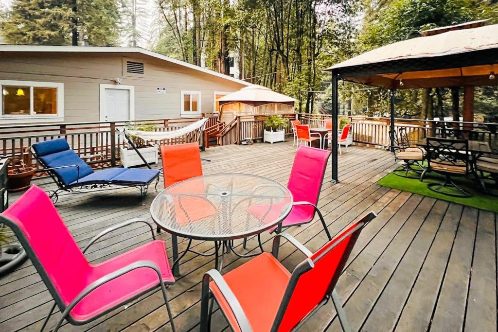 a deck with chairs and a glass table and chairs at River Paradise in Guerneville
