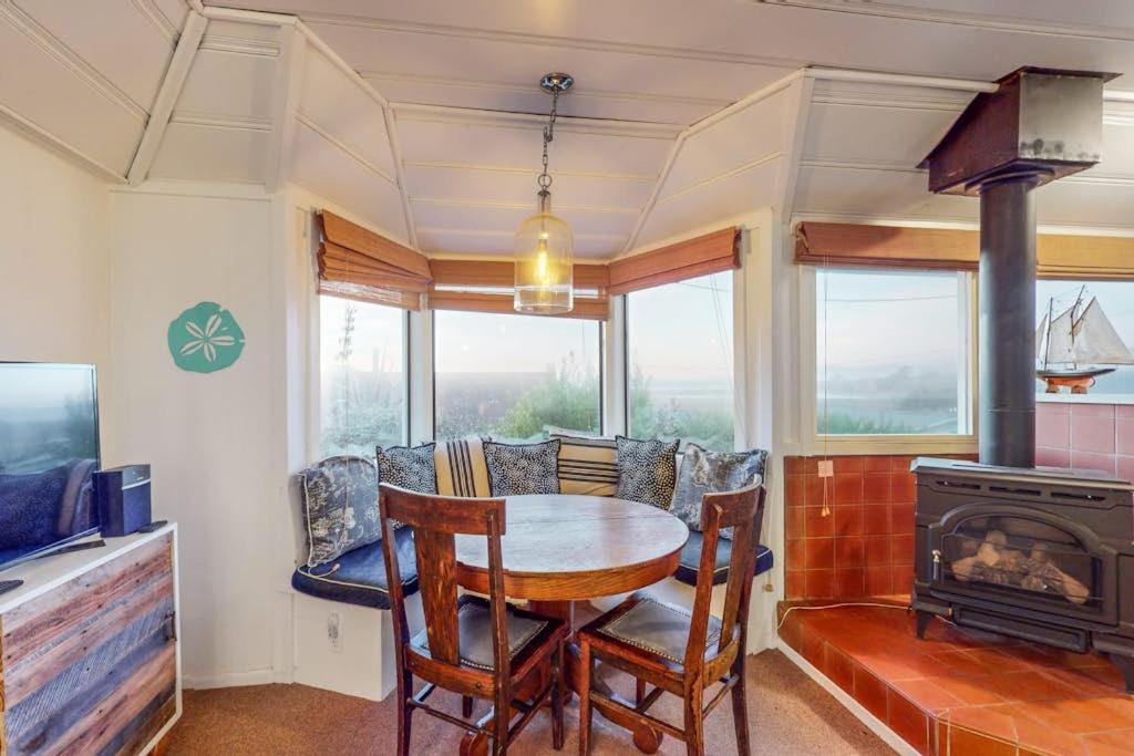 a dining room with a table and a wood stove at Seaside Cottage in Bodega Bay
