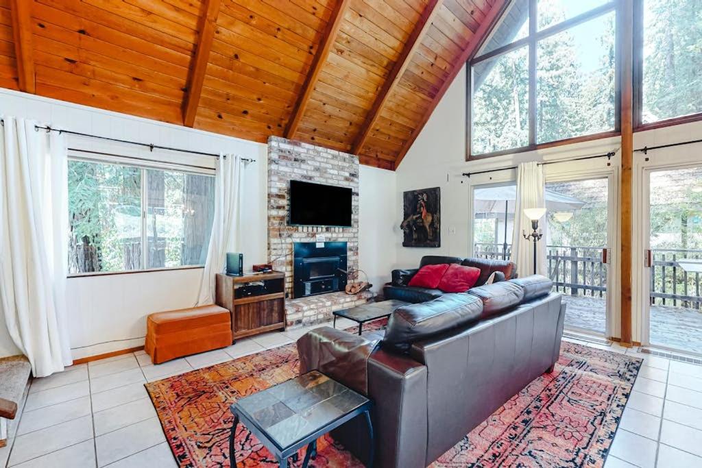 a living room with a couch and a tv at Redwood Lodge in Monte Rio