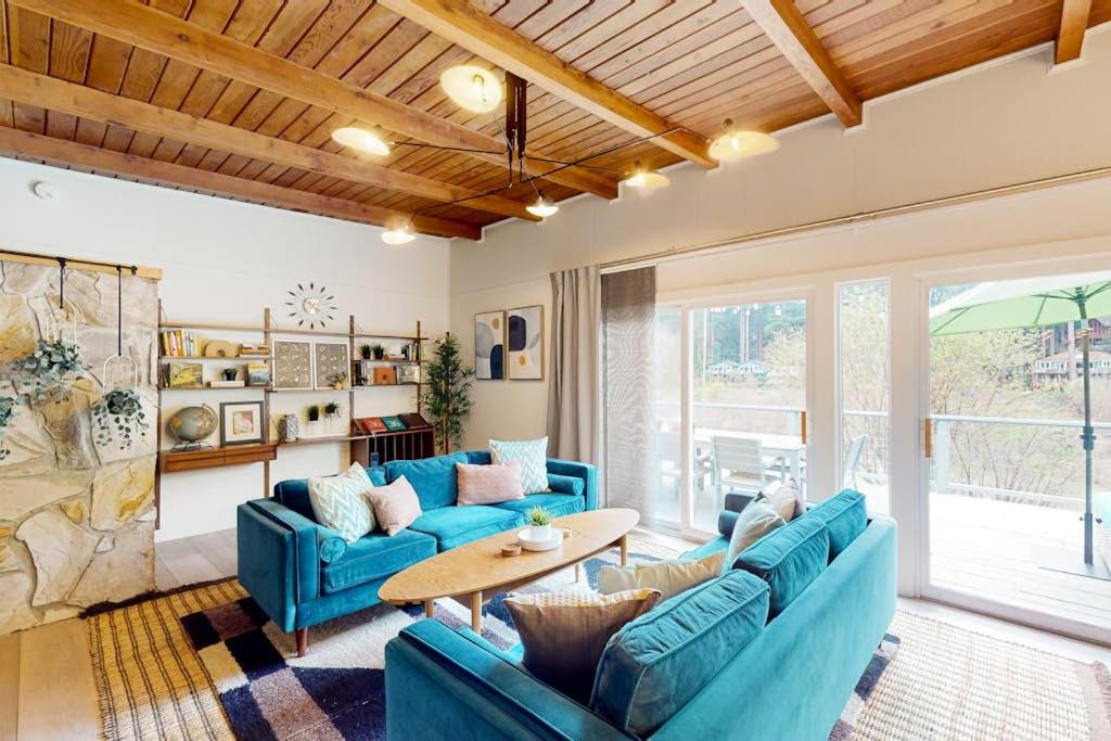 a living room with blue couches and a table at Riverfront Escape in Monte Rio