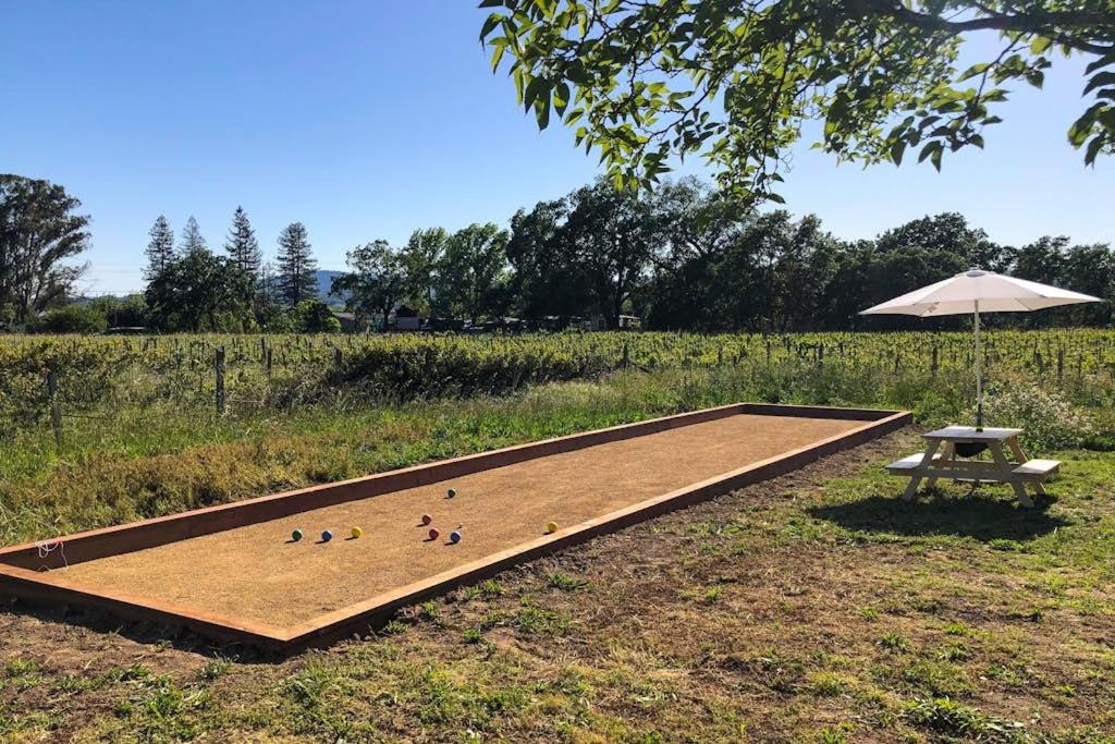 a picnic table and ducks on a board with an umbrella at Bird and Barrel Vineyard Farmhouse in Healdsburg
