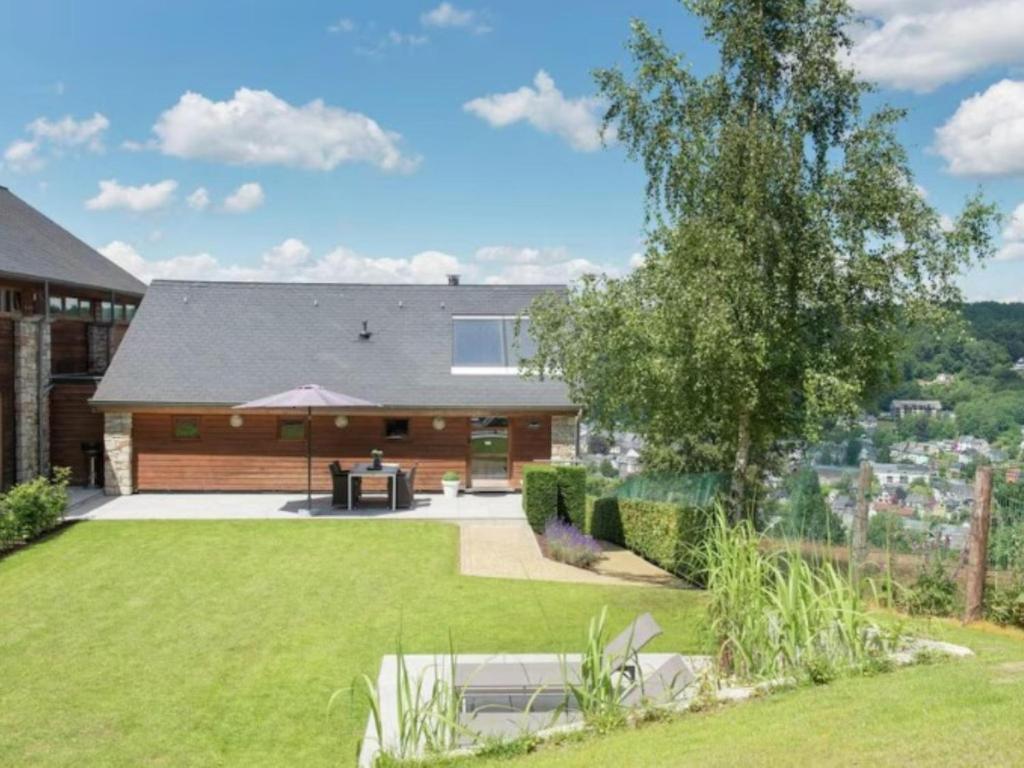 a backyard with a house with a lawn at Le Chemin des Framboises in Malmedy