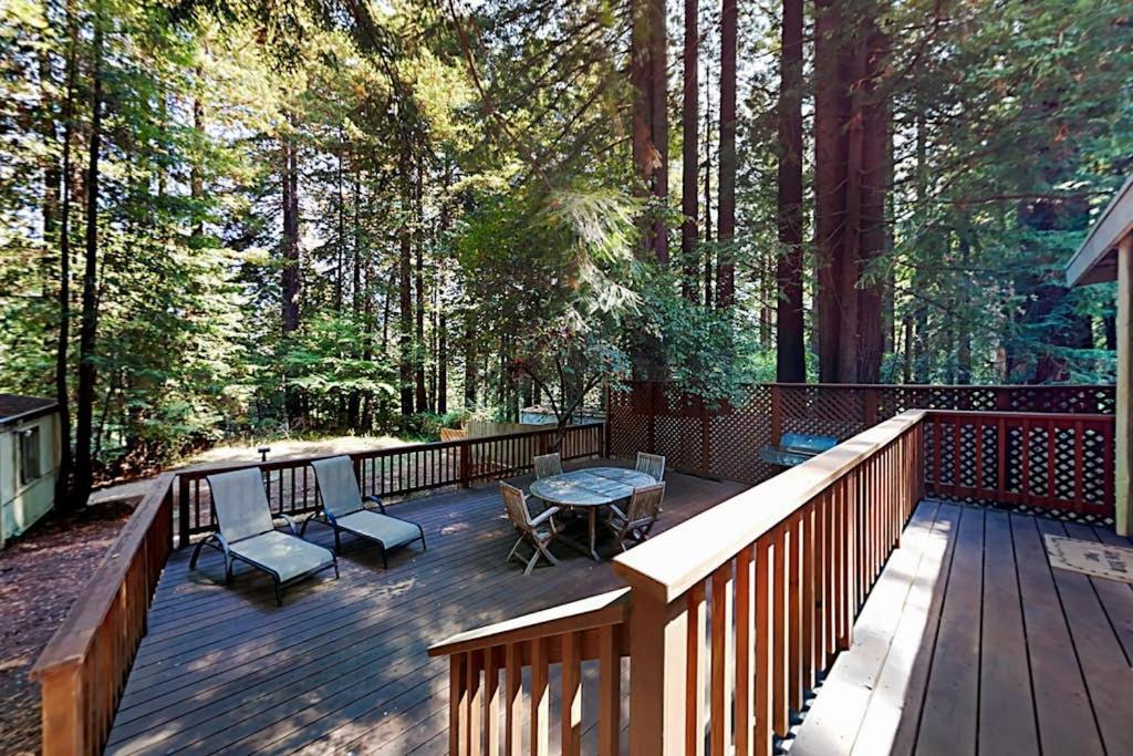 eine Holzterrasse mit Stühlen und einem Tisch darauf in der Unterkunft Wagging Woods in Cazadero