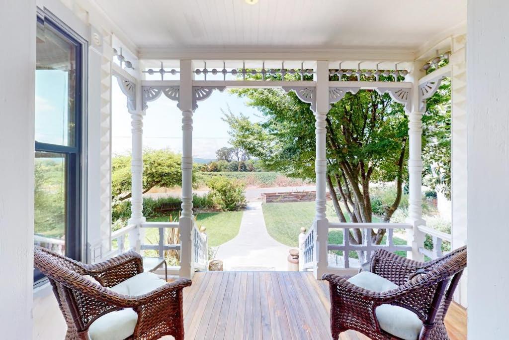 a porch with two chairs and a wooden table at Magnolia Ranch Vineyards in Healdsburg