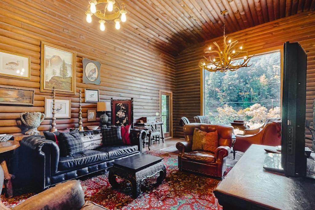a living room with a couch and chairs and a chandelier at Antler River Lodge in Guerneville