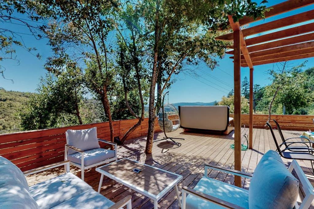 a patio with chairs and a television on a deck at Rooster Cottage in Healdsburg