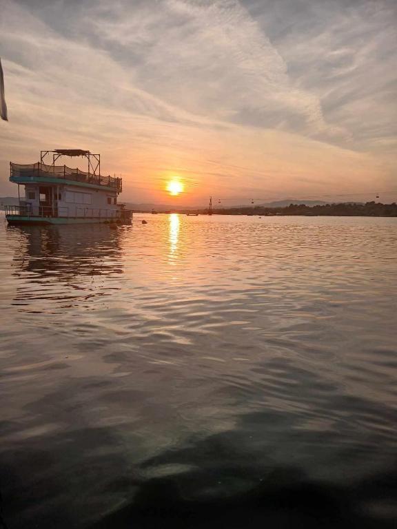 a boat floating on the water at sunset at Zeleni Biser- Green Pearl in Lukavac