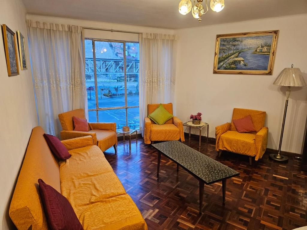 a living room with couches and chairs and a window at Zona Sur, Bajo Seguencoma Flat in La Paz