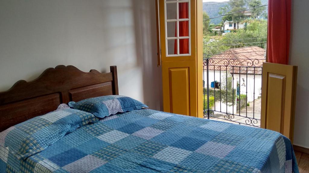 una camera con un letto con una coperta a scacchi blu e bianca di Sobradinho Tiradentes a Tiradentes