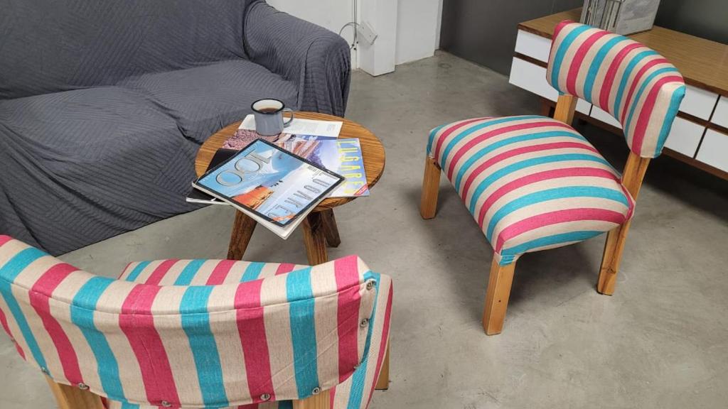 a living room with two chairs and a table and a bed at Departamento Martinez San Isidro con AA y Wifi velocidad Ideal para quienes necesitan alojarse cerca de clínicas como Trinidad San Isidro Las Lomas o Fertilitis excelente acceso desde Panamericana y Thames espacio comodo tranquilo y totalmente equipado in Martínez