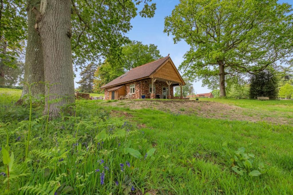 a log cabin in a field with a tree at 2 Bed in Waldron oc-v33536 in Waldron