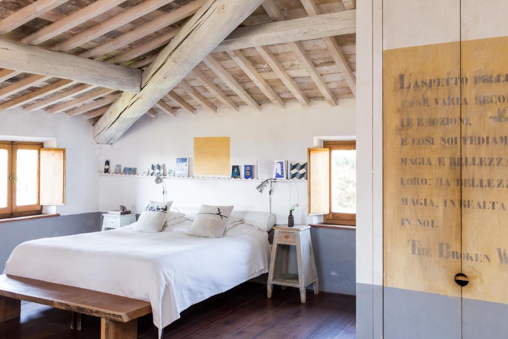 een slaapkamer met een wit bed en houten plafonds bij Agriturismo San Martino in Montepulciano