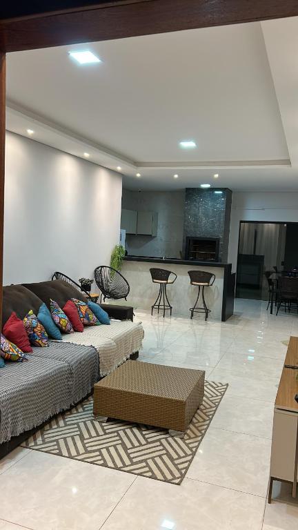a living room with a couch and a kitchen at Casa de temporada Tarumã in Tangara da Serra