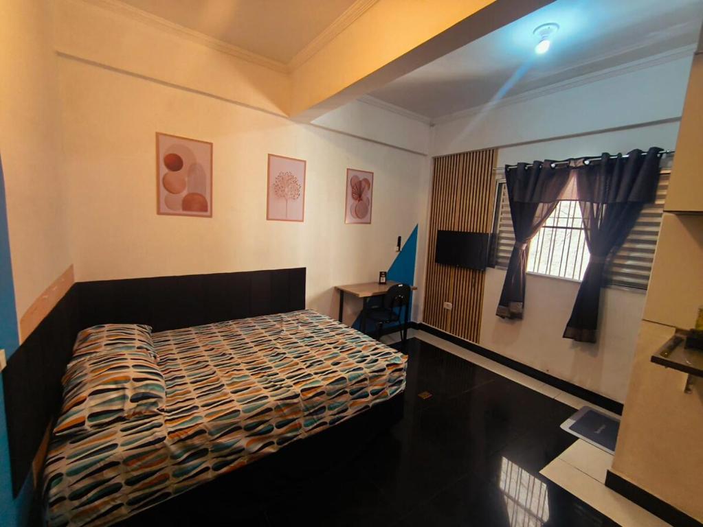 a bedroom with a bed and a window at Studio premium -- ap 06 in Diadema