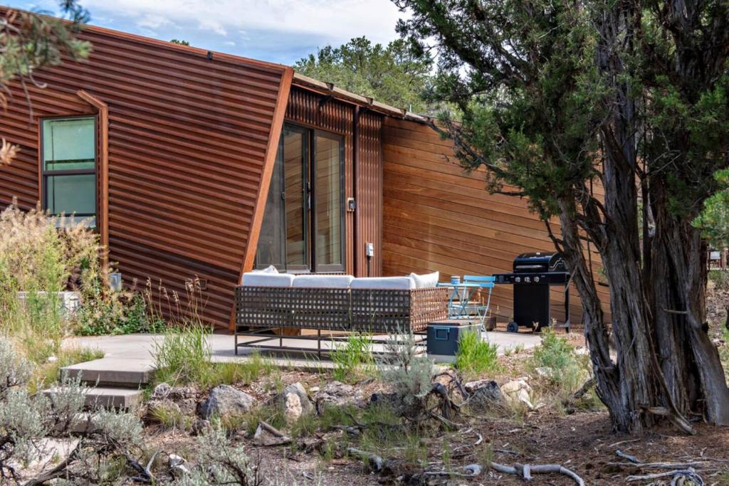 a home with a wooden facade and a tree at The Pinyon - Mountain View Retreat in Carbondale