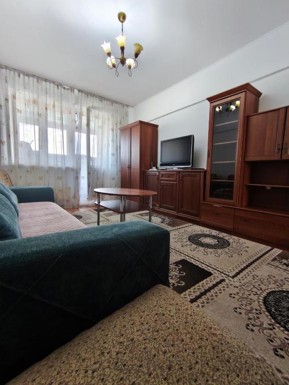a living room with a couch and a television at Xata 1+2 in Almaty