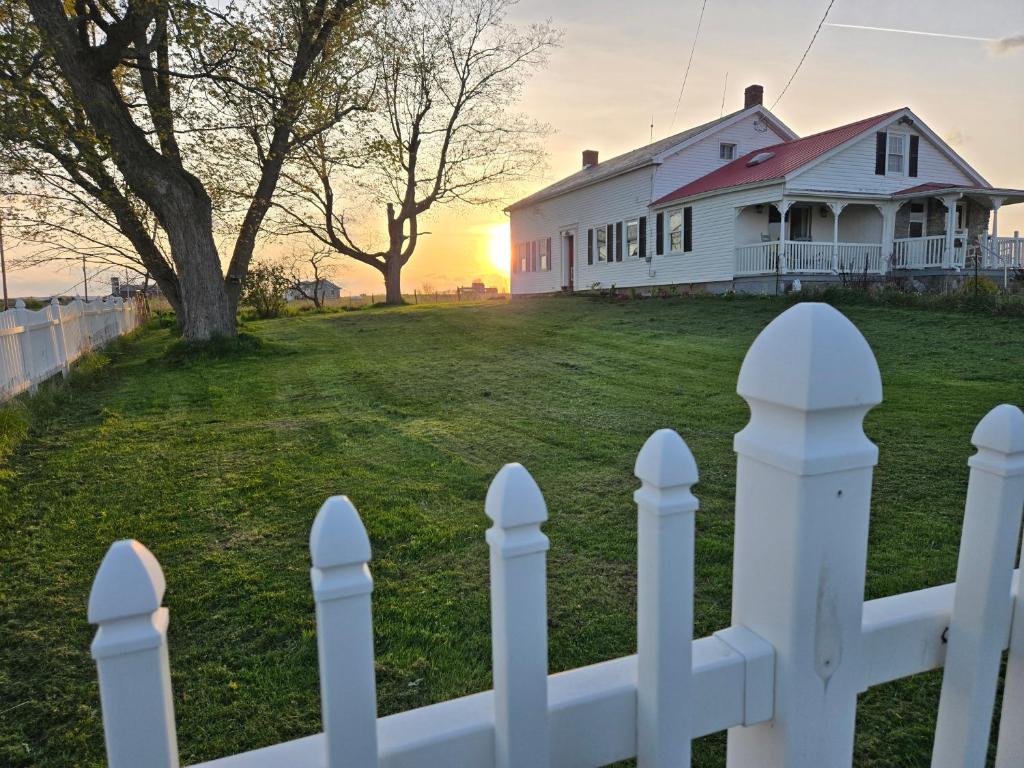 a white picket fence in front of a house at Peaceful Pasture Farm in Fort Edward