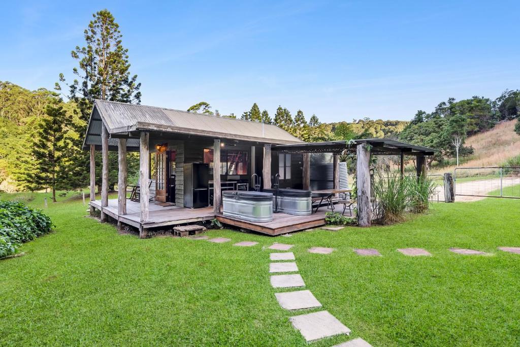a small house in a yard with a green lawn at Cascade Springs in North Tumbulgum