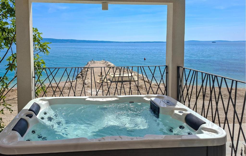 a bath tub on a balcony with a view of the ocean at Holiday Home Grljevacka Vi in Podstrana