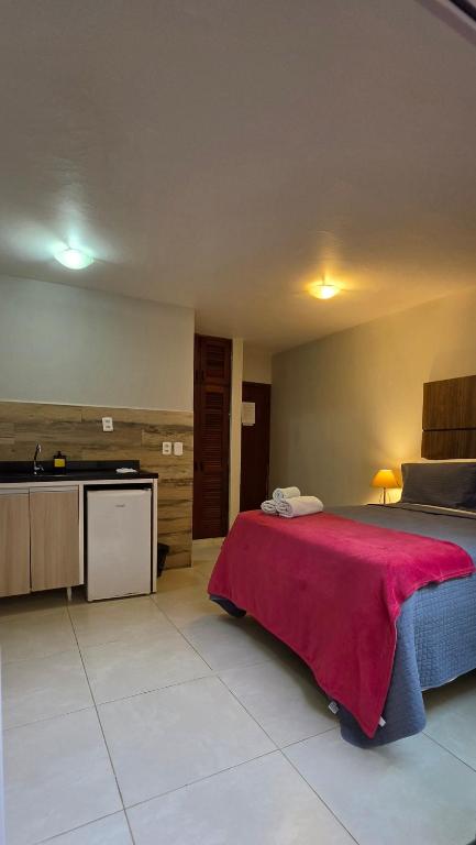 a bedroom with a bed with a red blanket on it at Flats Marina do Sol in Florianópolis
