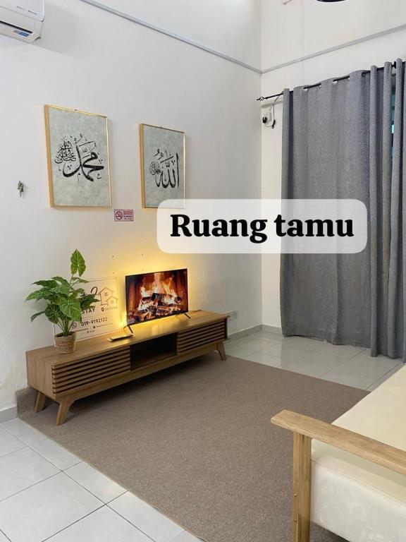 a living room with a fireplace in the middle at Twenty2 Homestay Sepang in Sepang