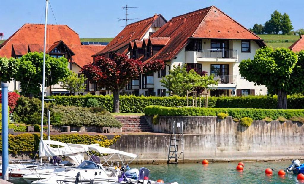 a large house with boats docked in the water at Ferienwohnung -West Häfele Blick in Hagnau