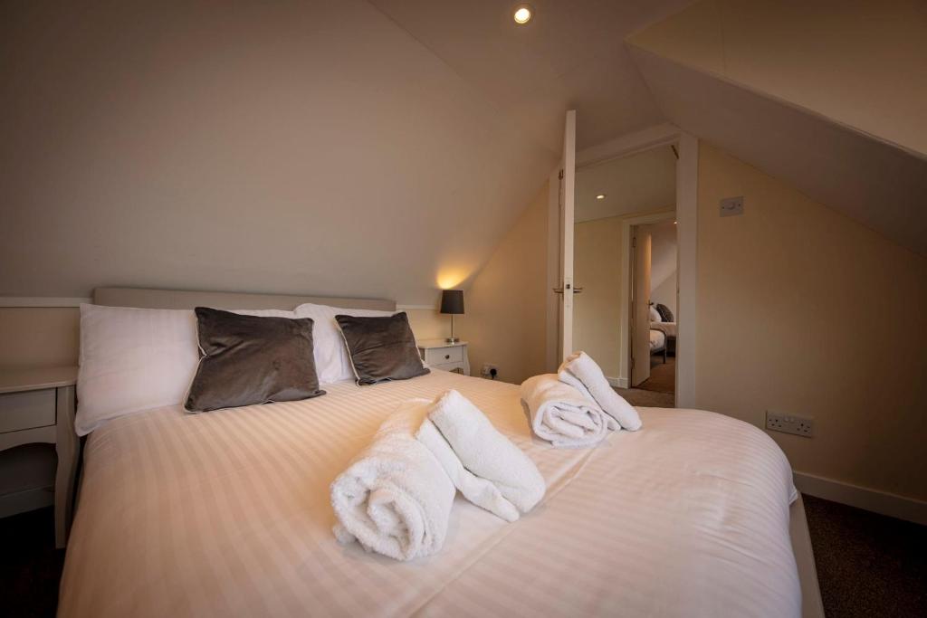 a bedroom with a bed with towels on it at Ard Dhub House Your 3 Bedroom cottage retreat in Waternish in Hallin
