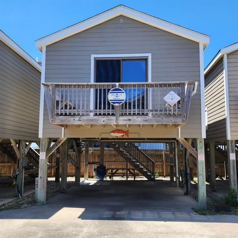 a house with a deck with a sign on it at NC 12 56821-9 Condo in Hatteras