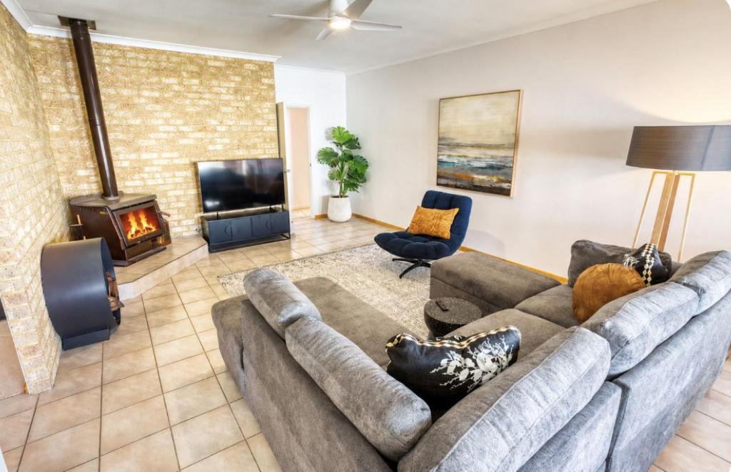 a living room with a couch and a fireplace at Ibis Rest Beach House in Geographe