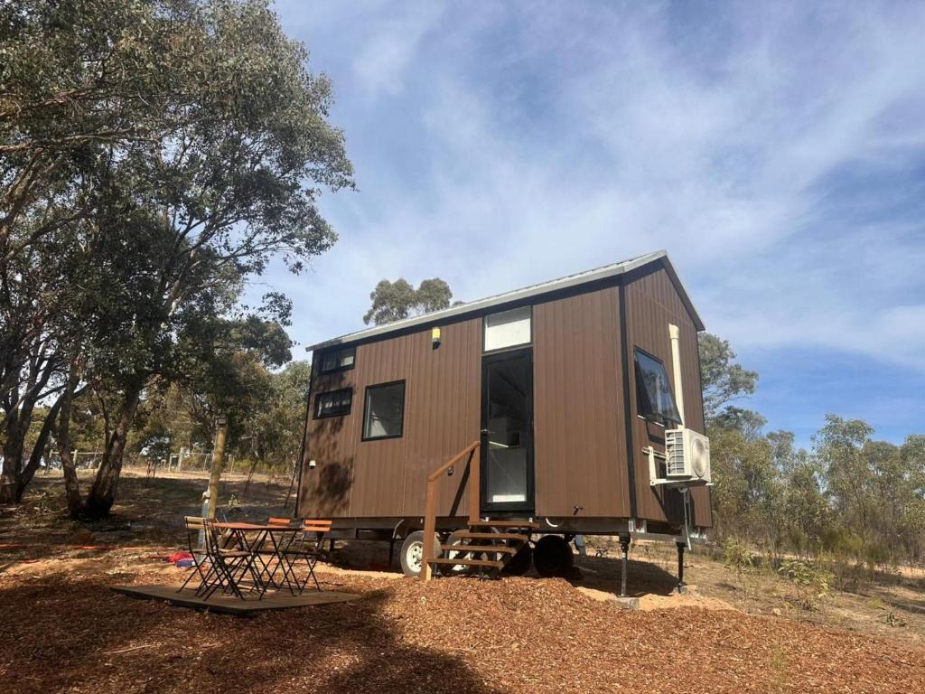 a brown tiny house parked in a field at Tiny House Adventure by Tiny Away in Tallarook
