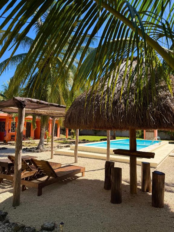 ein Resort mit Liegestühlen, Sonnenschirmen und einem Swimmingpool in der Unterkunft Hotel Bacalar Sunshine in Bacalar