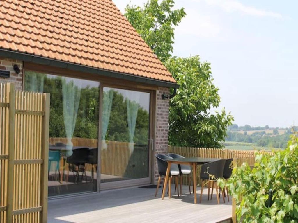 a pavilion with a table and chairs on a deck at Valomerius Charming holiday home in Maarkedal