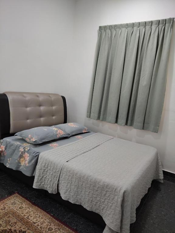 a bed sitting in a room with a window at Makwan Homestay C in Kubang Semang