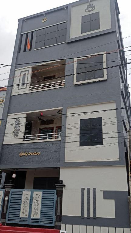 a gray building with a balcony and a building at Sri Durga Nilayam in Bhadrāchalam