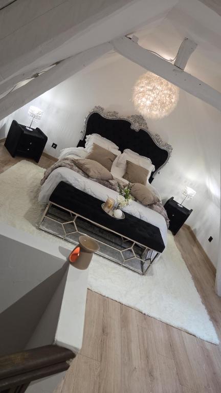 a bedroom with a large bed in a room at Le cocoon de choupette in Cuvilly