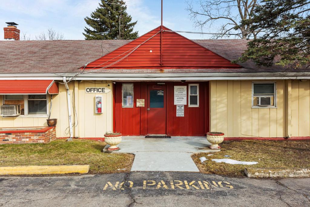 a house with a red door and a red roof at Budget INN in Flint