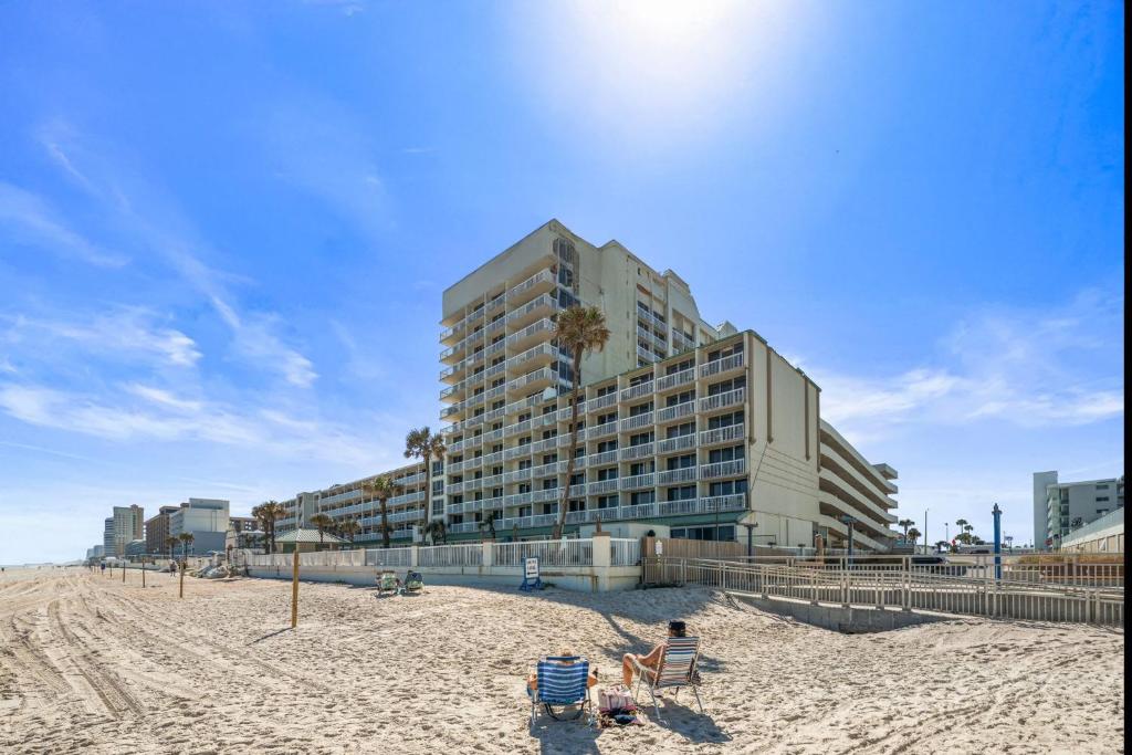 a large building on the beach with a sandy beach at Oceanfront 1BR Condo Daytona Resort Pool Access in Daytona Beach