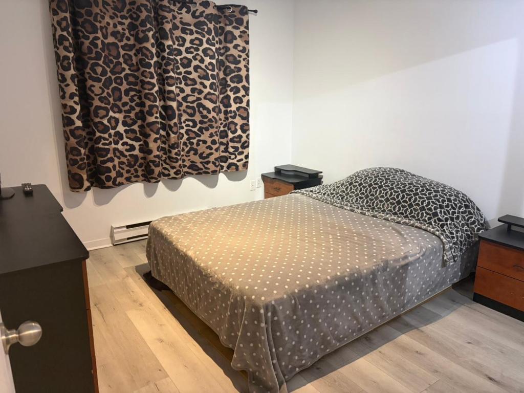 ein Schlafzimmer mit einem Bett und einem Vorhang mit Leopardenmuster in der Unterkunft EasyStay in Sherbrooke