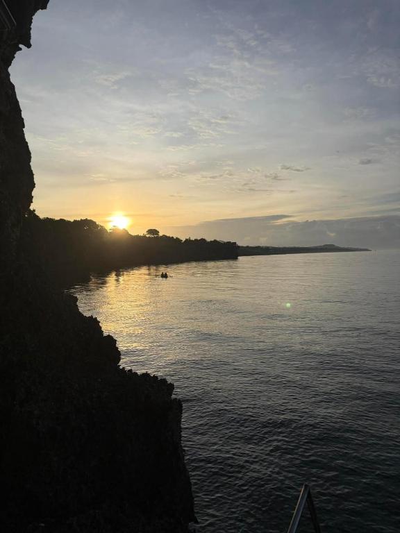a sunset over a body of water with the sun setting at Turtle's Cavern Oceanfront Resort in San Juan