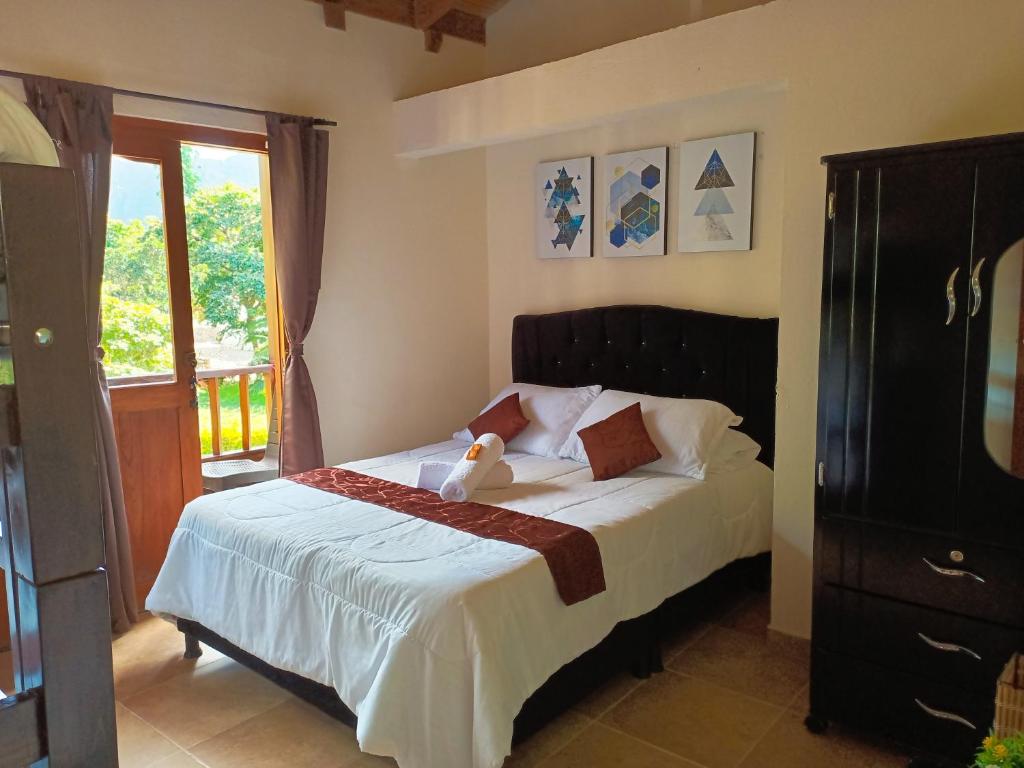 a bedroom with a bed with a teddy bear on it at Apartahotel Balcones de Nariño in Villa de Leyva