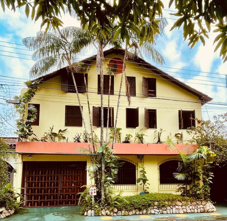 a yellow house with a palm tree in front of it at Casa Sankofa de Belém in Belém