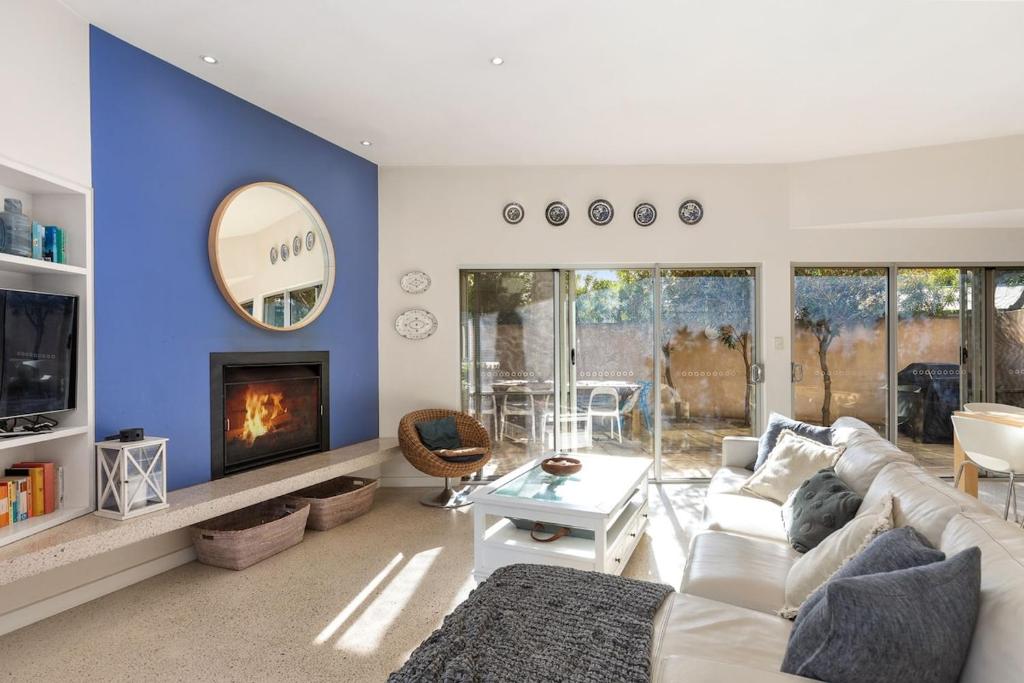 a living room with a white couch and a fireplace at Indigo Blue in Robe