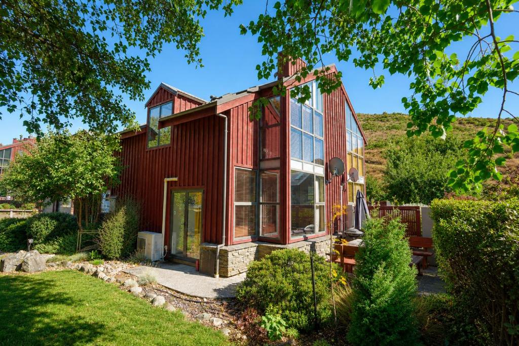 a red house with a glass facade at Cardrona Sanctuary by Aotearoa Escapes in Cardrona