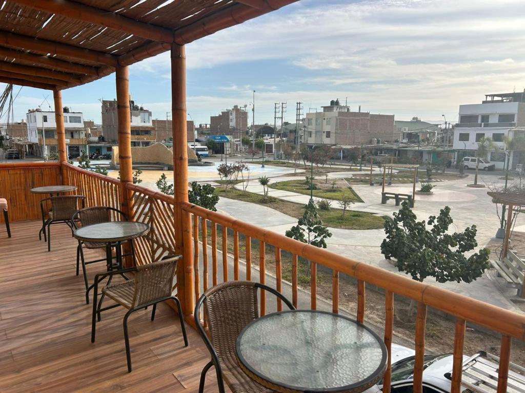 a balcony with tables and chairs and a view of a park at Flamante Atardecer in Paracas