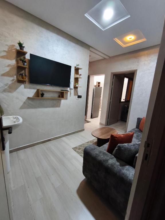 a living room with a couch and a flat screen tv at شقة مفروشة للكراء اكادير للعائلات فقط in Agadir