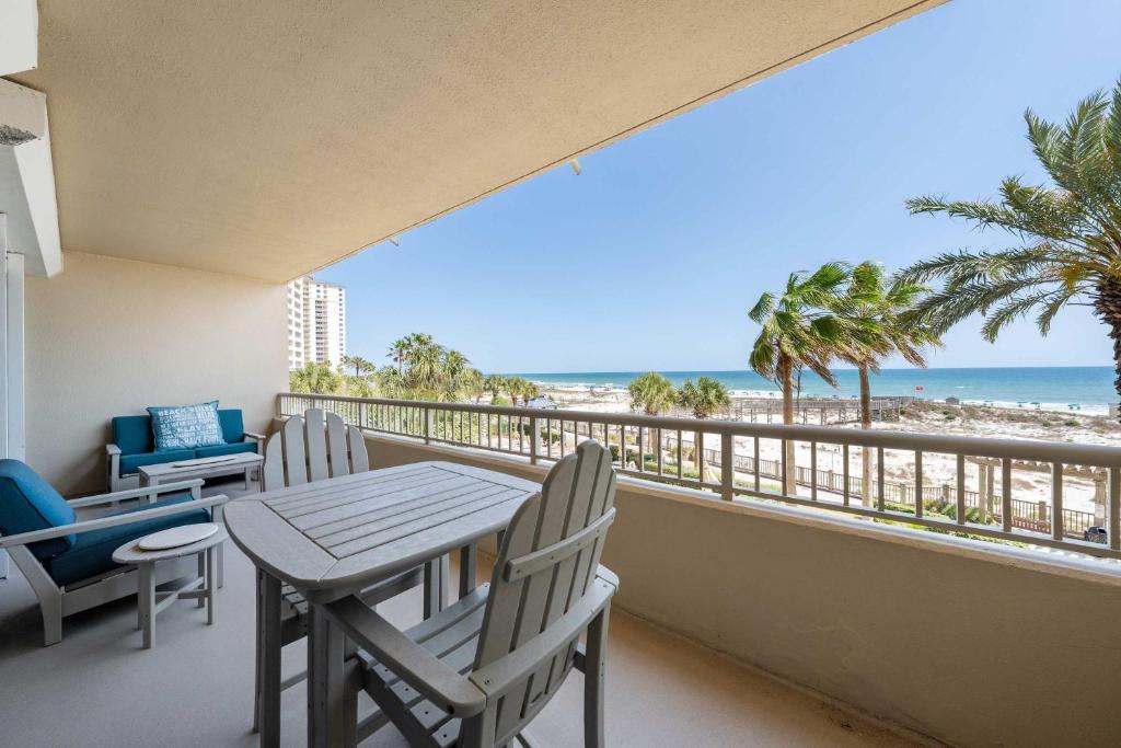a balcony with a table and chairs and the beach at 2BR Beach Condo Shared Pool Tennis Courts in Gulf Shores